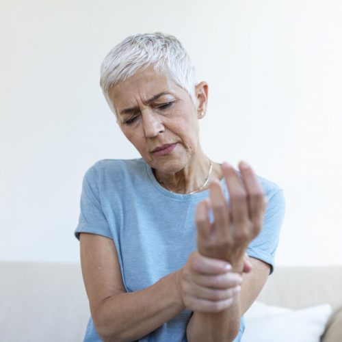 Elderly woman suffering from pain in hand, arthritis old person and senior woman female suffering from pain at home